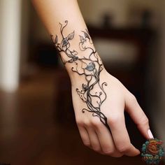 a woman's hand with a tattoo on it and vines growing out of the wrist