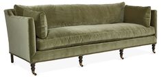 a green velvet couch sitting on top of a wooden frame