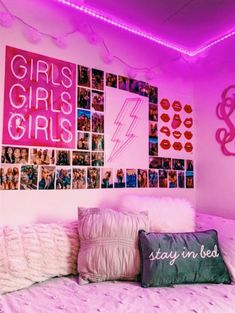 a bedroom with pink lights and pictures on the wall above it, along with pillows