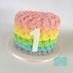 a rainbow cake with the number one on it