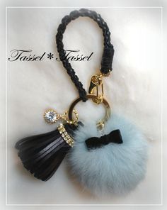 a black and blue pom - pom keychain on a white background