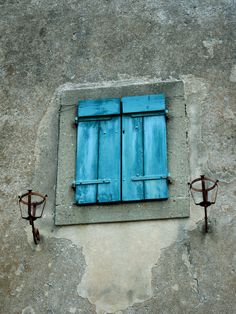 an old window with blue shutters on the outside