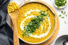 a white bowl filled with yellow lentils and garnished with cilantro