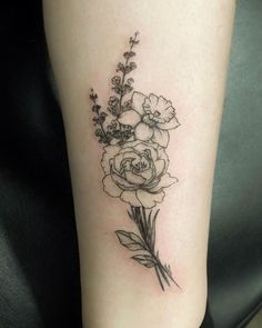 a black and white flower tattoo on the right leg, with an arrow in the middle