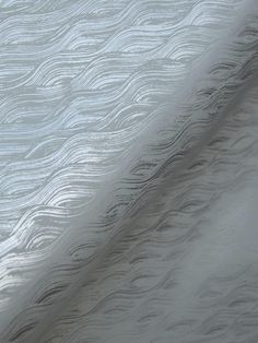 the textured fabric is white and has wavy lines on it, as well as an abstract pattern