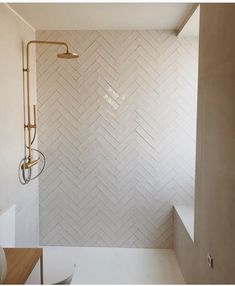 a bathroom with white tile and gold fixtures