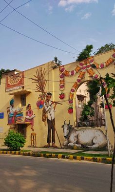 a mural on the side of a building with people and animals painted on it's sides