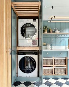 a washer and dryer in a small room next to a shelf with baskets