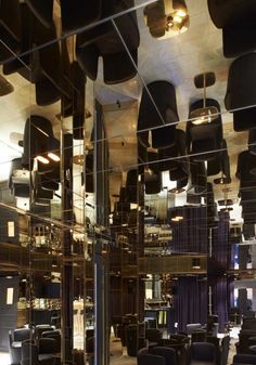 the interior of a restaurant with many chairs and lamps hanging from the ceiling above them