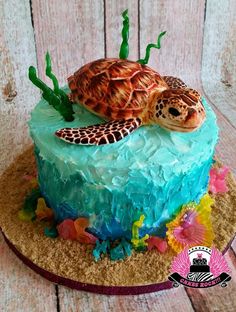 there is a cake that looks like a sea turtle on the beach with corals