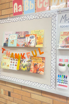 there are many books on the wall in this class room that is decorated with orange and yellow letters