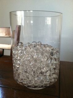 a glass filled with water sitting on top of a wooden table