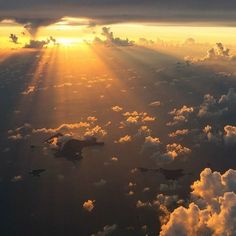 the sun shines brightly through clouds over water in this aerial photo taken from an airplane