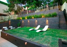 an outdoor living area with grass, lights and lawn furniture in the middle of it