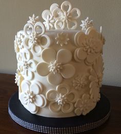 a close up of a white cake with flowers on it's icing and decorations