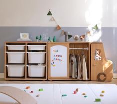 a child's playroom with toys and storage bins on the floor in front of it