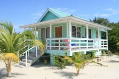 a small blue and white house on the beach