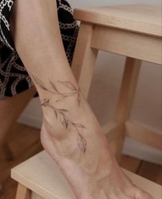 a woman's foot with a small tattoo on the left side of her leg