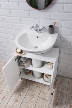 a white sink sitting under a mirror in a bathroom