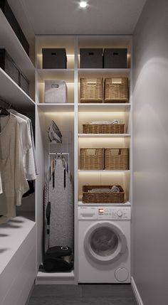 a washer and dryer in a room with clothes hanging on the shelves next to each other