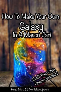 a jar filled with colorful liquid sitting on top of a wooden table next to a sign that says how to make your own galaxy in a mason jar