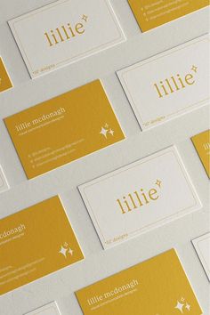 several business cards are stacked on top of each other with gold and white letters that spell out little