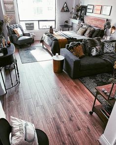 a living room filled with lots of furniture and decor on top of a hard wood floor