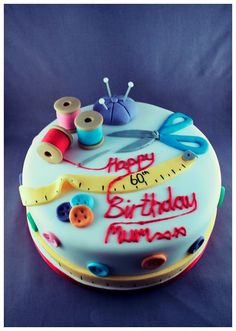 a birthday cake with sewing supplies on it