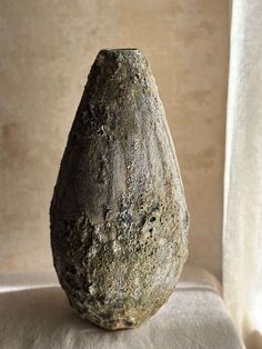 a stone vase sitting on top of a white cloth