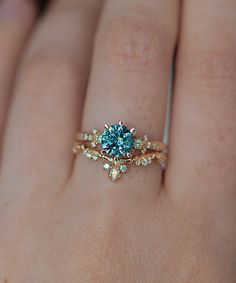 a woman's hand with a blue diamond ring on it