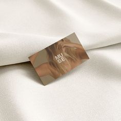 a close up of a white sheet with a hair tag on it's side