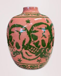 a pink vase with green designs on it