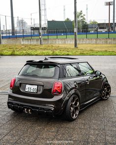 a small black car parked in a parking lot