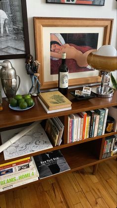 a table with books, figurines and other items on it next to a lamp