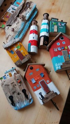 there are many small houses made out of wood and paintbrushes on the table