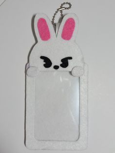 a white key chain with a pink bunny in the pocket