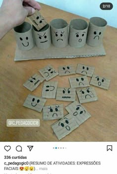 some toilet paper rolls with faces drawn on them and one is holding a piece of cardboard