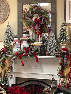 a mantel decorated for christmas with snowmen and wreaths on it, surrounded by other holiday decorations