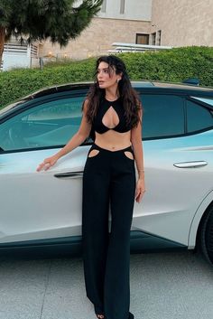 a woman standing next to a white car