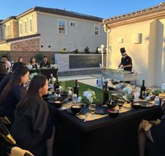 a group of people sitting around a table with food on it