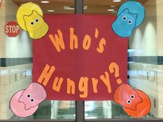 a red sign that says who's hungry? in front of a store window