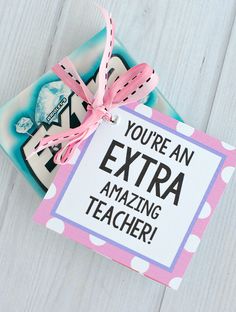 a card with the words you're an extra amazing teacher on it and a pink ribbon