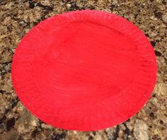 a red paper plate sitting on top of a counter