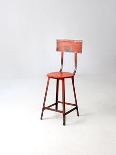 an old wooden chair with a metal backrest and seat up against a white background