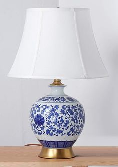 a blue and white lamp sitting on top of a wooden table