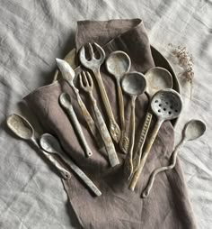 an assortment of old spoons and measuring spoons on a cloth