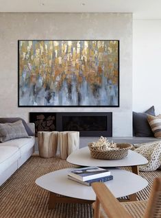 a living room filled with furniture and a large painting on the wall above the fireplace