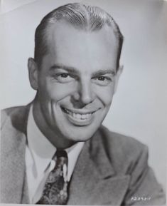 an old black and white photo of a smiling man