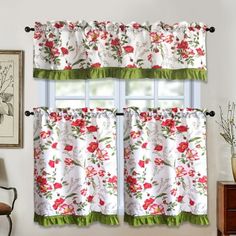 a window with red flowers on it and green trim around the valance, in front of a white wall