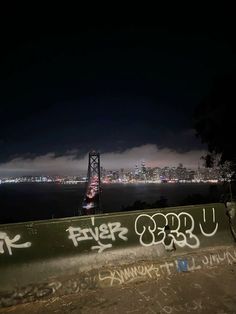 a man riding a skateboard on top of a cement wall next to the ocean